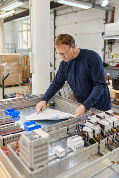 Electrician checking circuitry in workshop