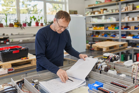 Electrician checking circuitry in workshop