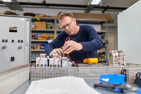Electrician working on circuitry in workshop