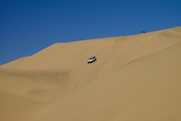 Fototapeta na wymiar Car driving in the dunes