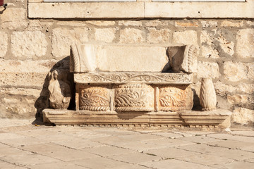 A bench in Korcula on the main square in front of St. Marks Cathedral. This bench is made of limestone composed out of different old elements
