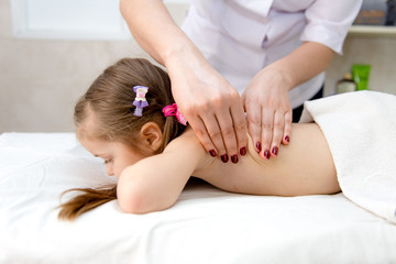 Obraz na płótnie Canvas woman doing massage to a little girl. Wellness massage for scoliosis