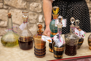 Collection of traditional glass gold painted carafes filled with strong typical Croatian liqueurs,...