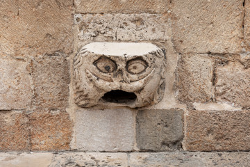 Maskeron in the Old Town of Dubrovnik, Dalmatia, Croatia. If you can hop onto the Gargoyle head, and take off your shirt while still standing facing the wall, luck in love will follow you