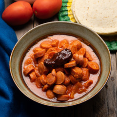Mexican sausage with chipotle sauce on wooden background