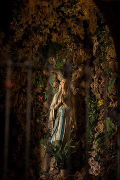 Our lady Maria statue praying in the Jesuit church in the Old Town of Dubrovnik, Dalmatia, Croatia.  She is surrounded by rocks and greenery
