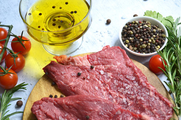 fresh vegetables and raw meat with herbs and spices, food background top view