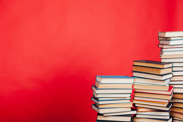 a lot of educational books for exams at school on the red background of the library