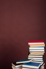 a lot of educational books for exams at university on the brown background of the library