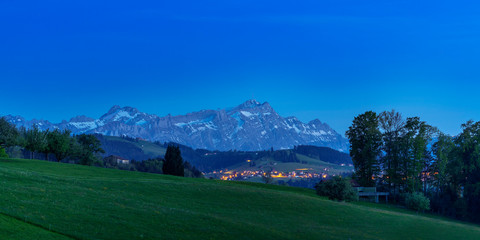 Alps in the evening sky behind a beautiful little illuminated village