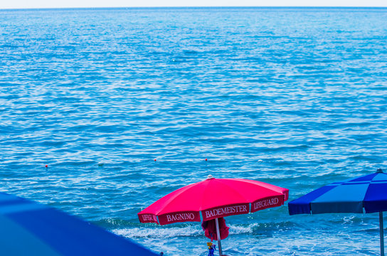red umbrella and lifeguard chairs for your safety at the sea