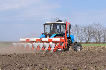 A farmer on a tractor prepares farmland with a bed for next year