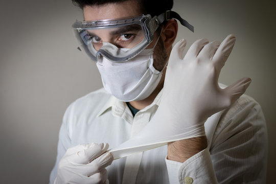 Homem caucásio branco brasileiro em fundo branco usando mascara e luva e óculos de segurança equipamento de proteção individual médico ou doutor em Combate ao Coronavírus
