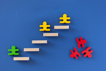 figures of men green yellow red climb the stairs and fall down, classic blue background