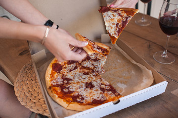 Party people and eat pizza. Pizza in a box on a wooden table