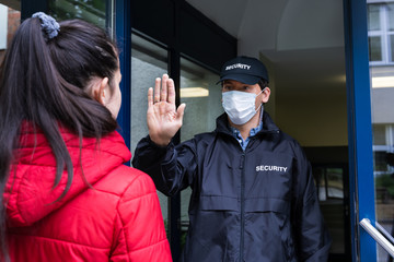 Security Guard Making Stop Hand Gesture To Woman
