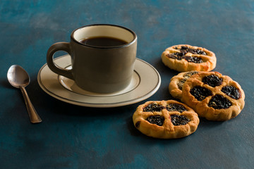 Some cookies and a cup of coffee on a blue table.
