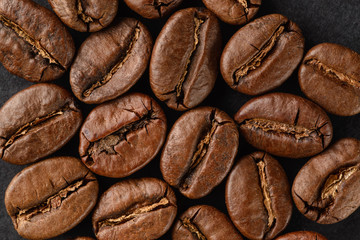 Roasted coffee beans on a black background, detailed macro.