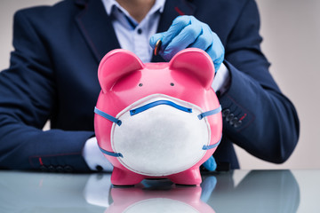 Inserting Coin In Piggybank To Save Money