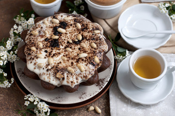 Chocolate cake with peanuts on table with tea and flowers