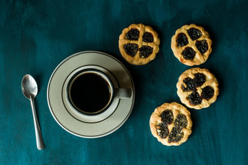 Some cookies and a cup of coffee on a blue table.
