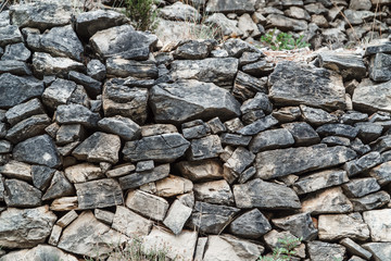 Wall of gray stones of different sizes, close-up.