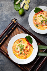 Asian Shrimp Tom Yam with funchosa on white plates. Top view, copy space