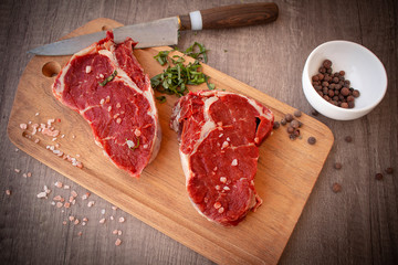 Aerial view of two Black Angus rib eye steaks on a rustic wooden board