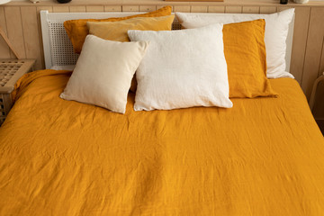 Fototapeta na wymiar orange linen bed linen with white and orange pillows. cozy home
