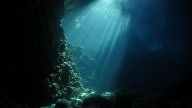 sun rays sun beams and sun shine underwater in cave beautiful light scenery scuba divers to see