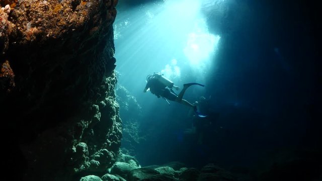 sun rays sun beams and sun shine underwater in cave beautiful light scenery scuba divers to see
