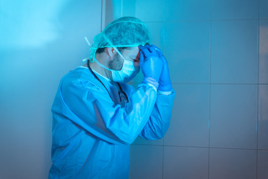 Un doctor  mostrando preocupación por resultados de un análisis o muestra de sangre en un test o jeringuilla tras el estrés vivido debido a la pandemia o virus, llamada Coronavirus o Covid-19.