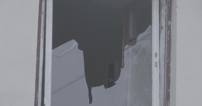 A Broken Window And A Stone Flies From A Window