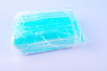 Bundle of surgical face mask in plastic on white table