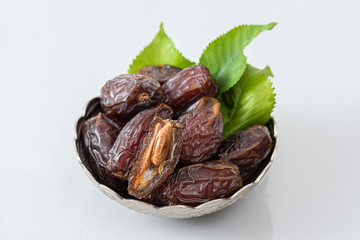 Palm dates on the silver plate, gray background.
