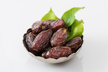 Palm dates on the silver plate, white background.
