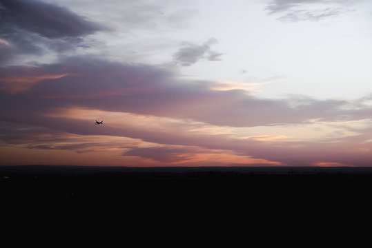 An airplane flying in a sunset sky over Albuquerque, New Mexico. 