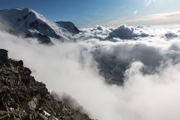 Fototapeta na wymiar Clouds and fog over the Chamonix valley. View from the Cosmique refuge, Chamonix, France. Perfect moment in alpine highlands.