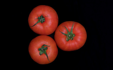 Red and fresh tomatoes isolated on black background. Fresh vegetables, healthy food, bright color.