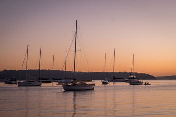 Fototapeta na wymiar apricot dawn on the water with yachts