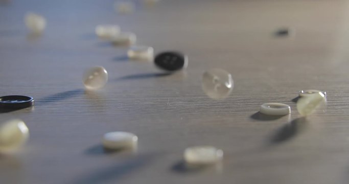 Slow motion of close-up of various colorful buttons on a table. Different colored buttons made of plastic. Sewing supplies, Accessories for clothes, Sewing thread, Sewing buttons,Textile accessory