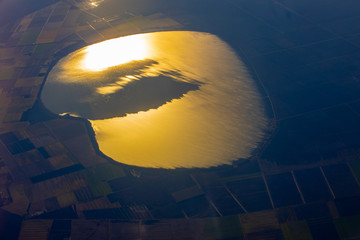 sun and clouds reflection in the water body from areal view 