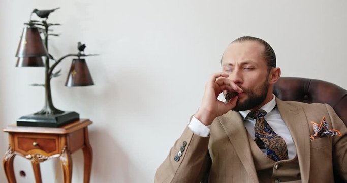 Pensive classy man smoking cigar in room