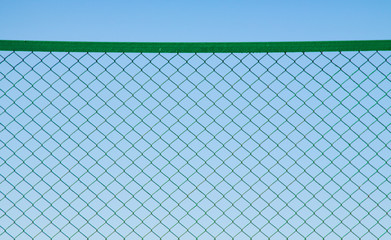 Metallic green mesh against the sky.