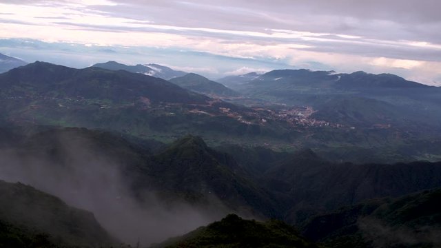Ciudad entre monta&ntilde;as y nubes con un gran telef&eacute;rico que atraviesa