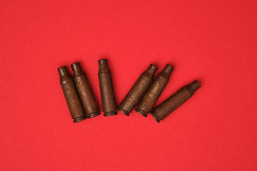 empty cartridges for the machine gun on a solid red background