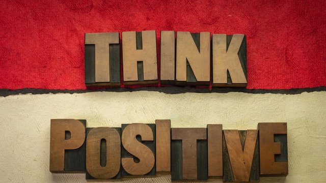 Think positive - word abstract stop motion animation in vintage letterpress wood type blocks against colorful handmade papers, optimism and mindset concept