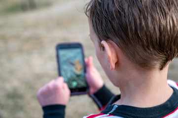 Caucasian boy playing a mobile app game.
