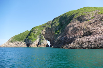 Huge hexagonal columnar joints of volcanic rock at Hong Kong Global Geopark, China, with cave made...