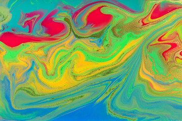 Neon colored marble pattern with golden glitter. Fluorescent liquid background. Artwork abstract bright texture.